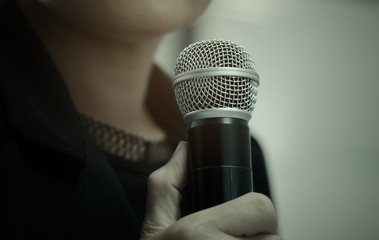 blurred of businesswoman speech, talking with microphone, gray scale tone