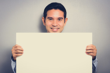 Empty white paperboard held by a man with smiling face