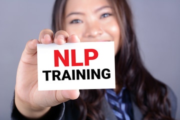 NLP TRAINING, message on the card held by a woman