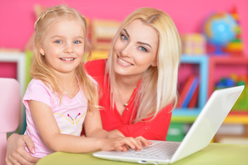 Fototapeta na wymiar woman and little girl using laptop