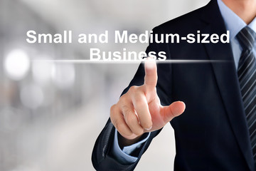 Businessman hand touching Small and Medium-sized Business (or SMB) text on virtual screen