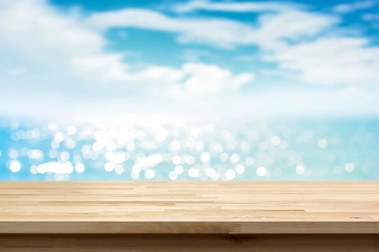 Wood table top on blur shiny sea water and summer sky background