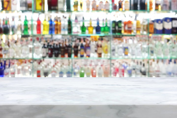 White stone bar top on blur colorful alcohol drink bottle background