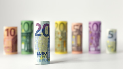 Gerollter 20 Euro Schein mit anderen Geldscheinen im Hintergrund