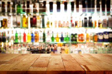 Wood bar top on blur colorful alcohol drink bottle background - obrazy, fototapety, plakaty