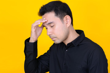Young Asian man with hand on temple