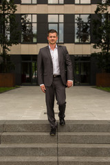 Business Mann / Herr verlässt Arbeitsgebäude / Feierabend / Termin