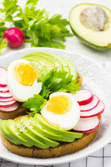 Healthy vocado sandwiches with eggs and radish. Healthy breakfast. Clean eating concept. 