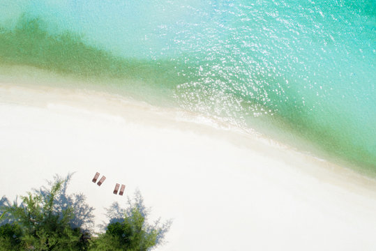 Aerial drone shot of white sand beach with turquoise sea water