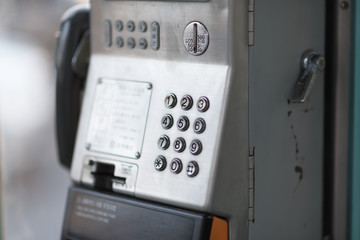 old pay telephone on a city street. Silver color phone