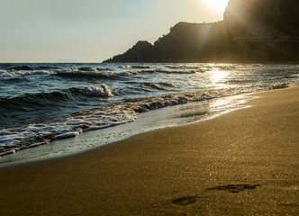 Beautiful sandy Mediterranean beach  at  sunset  and footprints on the sand.