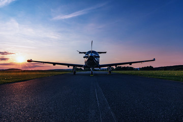 Single turboprop aircraft on evening runway.