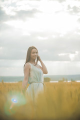 Beautiful girl in a wheat field in the sunset sun