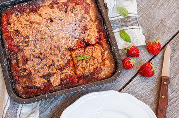 Strawberry homemade pie on a wooden background.