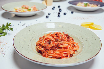 Spaghetti pasta with bolognese sauce on white table.