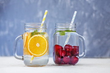 Fruit cocktail with cherries. Detox water with lemon, orange and mint.The concept is summer, diet, vegetarian, fitness, healthy eating and lifestyle.