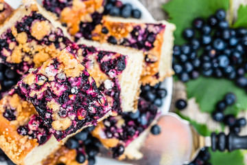 Sweet cake pieces with fruits of blueberry on yeast pie, summer baking concept from above