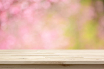 Wood table top on blurred background of pink cherry blossom flowers