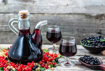 Crédence de cuisine en verre imprimé Alcool Fruit liquor in a bottle and glass of sweet alcohol on wooden table