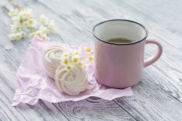 Cup of coffee, homemade marshmallow and jasmine branch on grey wooden table