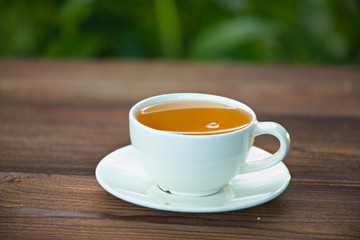 porcelainl cup with green tea on table