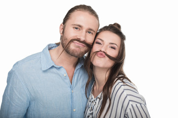 Fototapeta premium Happy young couple making false moustache from hair and smiling at camera