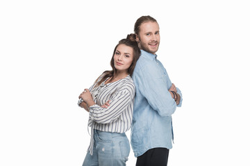 Obraz premium Happy young couple standing back to back and smiling at camera