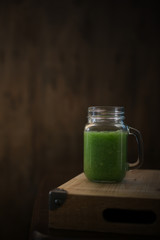 Healthy green smoothie on a wooden table. Selective focus