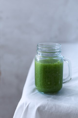 Fresh organic green smoothie with spinach, cucumber on a white tableware