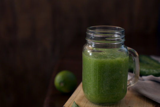 Healthy green smoothie on a wooden table. Selective focus