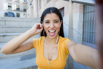 attractive latin woman listening to music on her smart phone