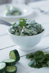 Cucumber salad with yogurt dressing on the white background. Vertical orientation