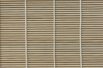 Japanese bamboo mat for rolled sushi. Close up bamboo sushi mat texture for background or wallpaper for your design. Bamboo sushi mat in macro concept for background.