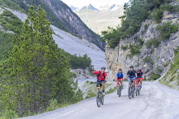 eine Gruppe Radsportler beim bewältigen einer Steigung auf einem Schotterweg