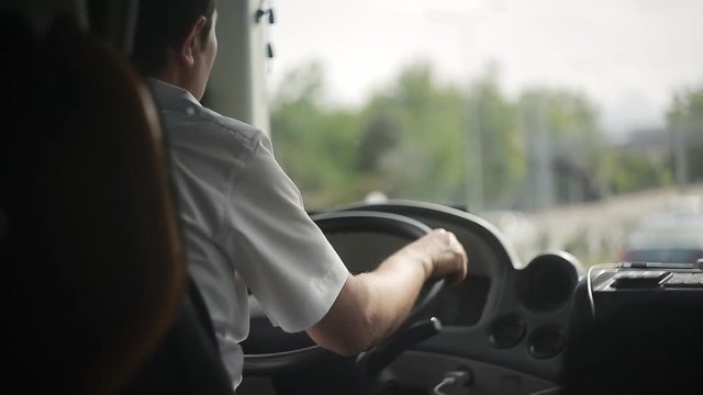 The bus driver is driving along the road.