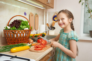 girl chopping tomatoes, vegetables and fresh fruits in kitchen interior, healthy food concept