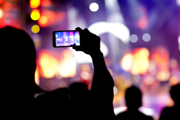 Fototapeta na wymiar People at concert shooting video