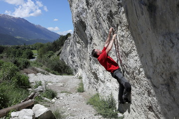 Sportler klettert an Naturfels
