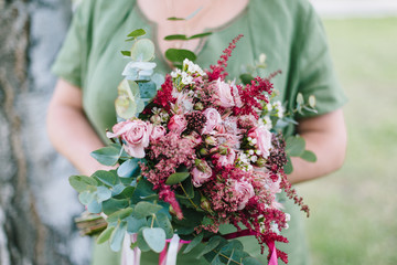 Rustic wedding bouquet in woman's hands.