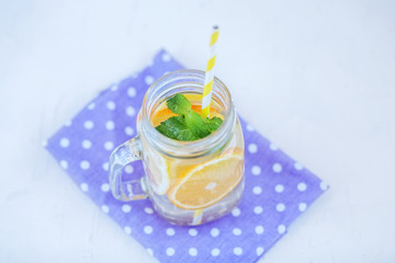 Refreshing detox water with lemon, orange and mint. Glass jar and a napkin. The concept is summer, diet, vegetarian, fitness, healthy eating and lifestyle.