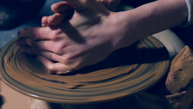 Close up of hands shaping clay pot