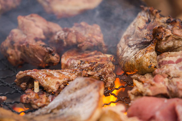 Close up barbecue pork roasting on charcoal grill with bright flame Selective focus.