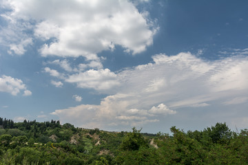 Fototapeta na wymiar Landschaft in der Toskana mit Hügel und weissen Wolken