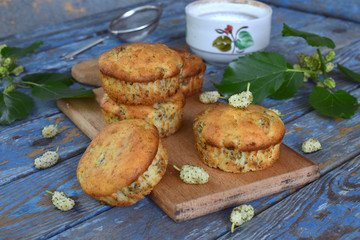 Homemade sweet muffins with white mulberry. Berry cupcakes on a wooden background.