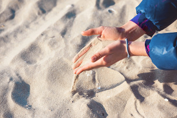 Young girl's hands holding sand