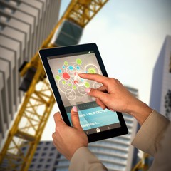 Composite 3d image of businesswoman using digital tablet