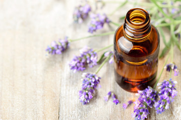 Lavender essential oil in the amber bottle, on the wooden table