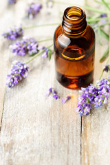 Fototapeta na wymiar Lavender essential oil in the amber bottle, on the wooden table