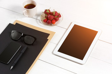 Modern workplace with digital tablet computer and mobile phone, cup of coffee, pen and empty sheet of paper.