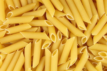 uncooked penne rigate pasta closeup food background texture